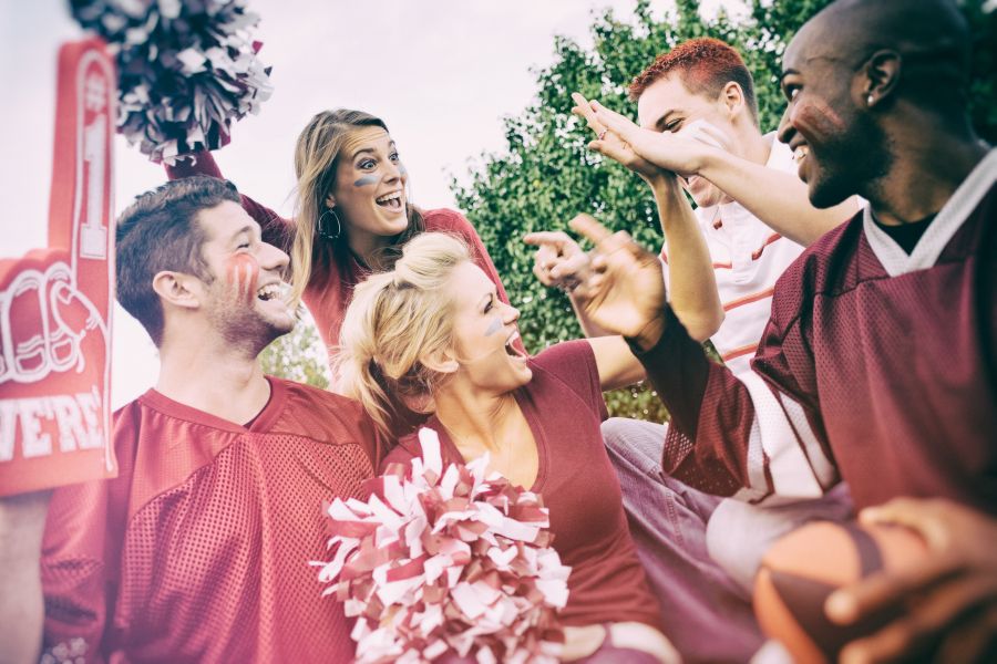 people cheering for the same sports team wearing maroon